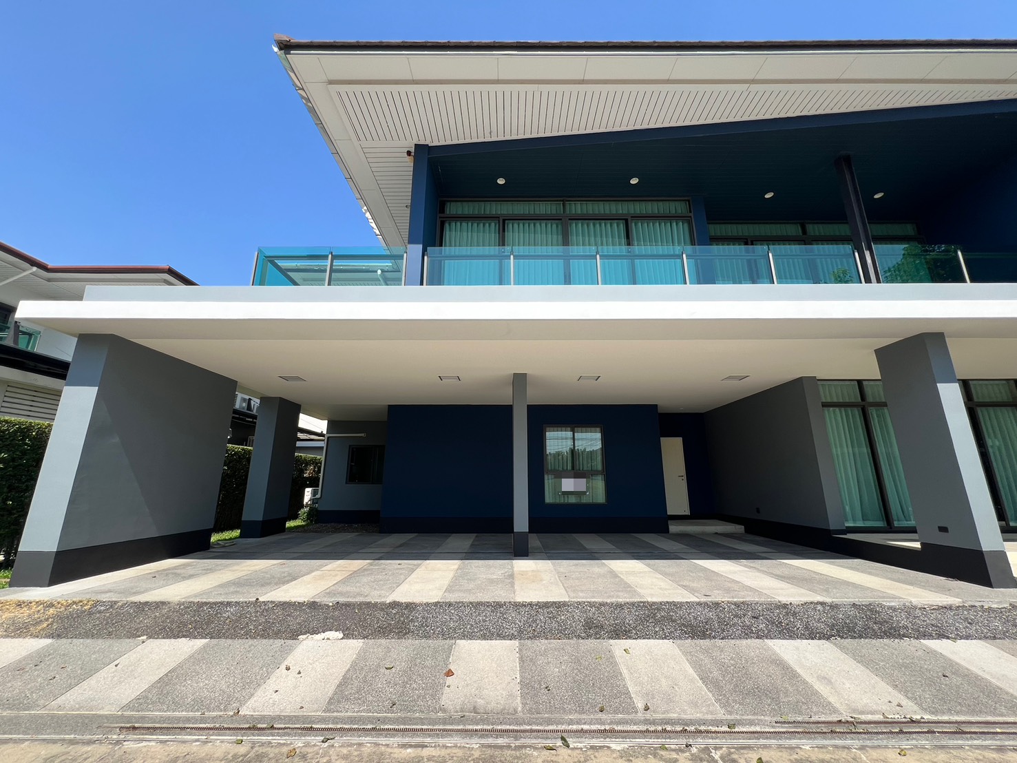 Detached House for rent in Bang Kapi, Bangkok - Covered multi-car carport beneath an upper-floor glass balcony.