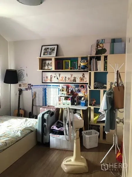 Townhouse for sale in Phasi Charoen, Bangkok - Cozy bedroom with bed, shelving and study items against a bright window.