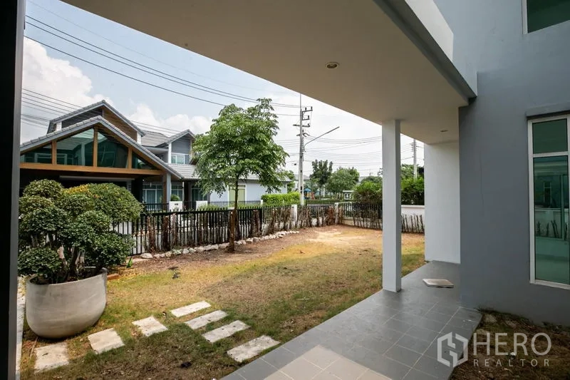 บ้าน ให้เช่าหรือขายในLam Luk Ka, Pathum Thani - เฉลียงคลุมหลังคามองเห็นสวนหน้าบ้านและรั้ว