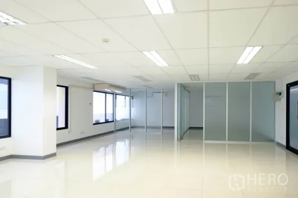 办公空间 出租在Chatuchak, Bangkok - 开放式办公室，白色瓷砖地面，吊顶灯光与玻璃隔断。