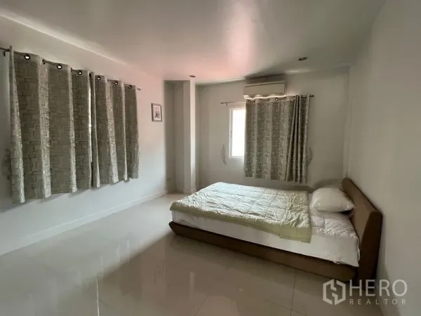 独立式住宅 出租在Bang Kapi, Bangkok - 宽敞卧室，双人床、瓷砖地面、窗帘与空调。