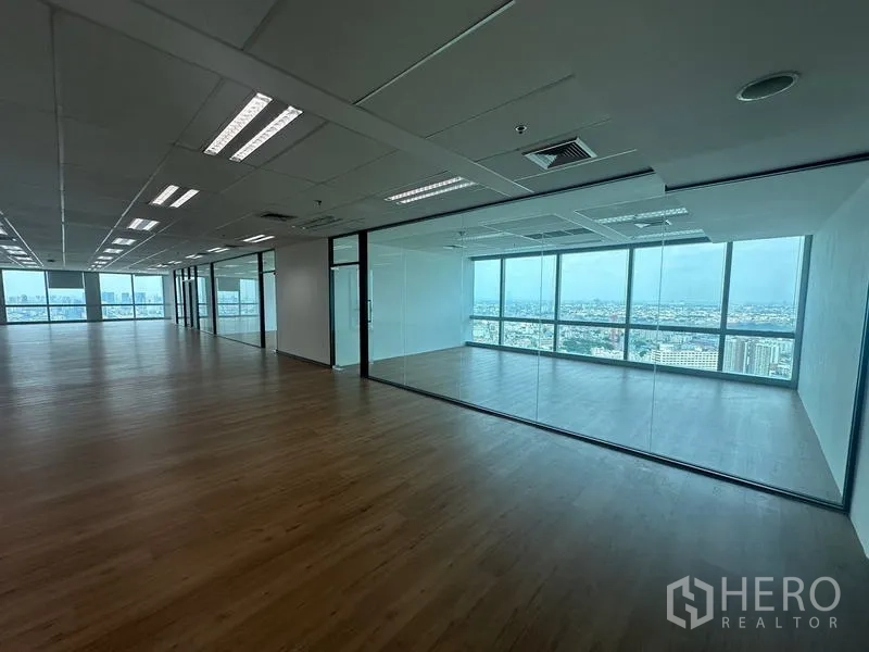 Office Space for rent - Corner glass meeting room with full-height windows and panoramic city views beside the open workspace.
