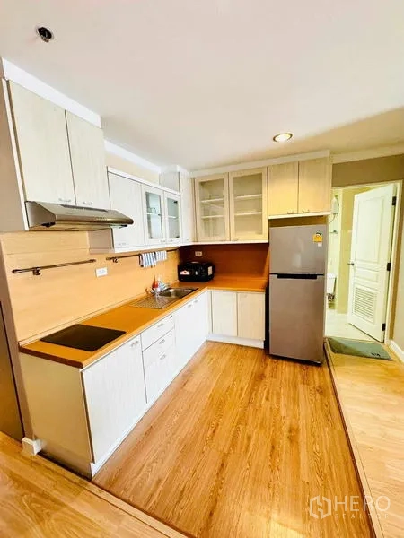 คอนโด ให้เช่าในKhlong Toei, Bangkok - ครัวบิวท์อินรูปตัว L พร้อมเครื่องดูดควัน ตู้กระจก และพื้นไม้