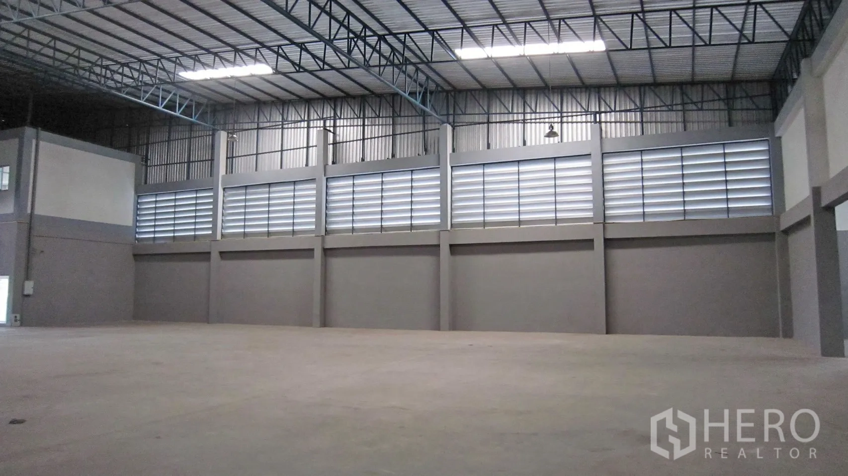 Warehouse for rent in Bang Sao Thong, Samut Prakan - Warehouse wall with ventilation louvres and open floor area under a high roof.