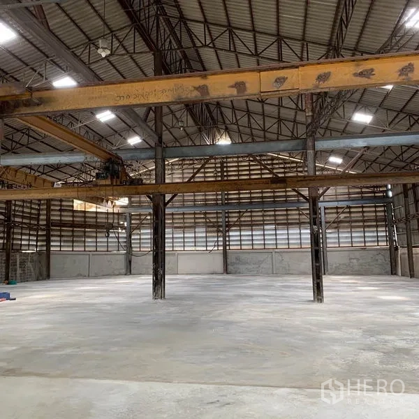 Warehouse for rent in Yan Nawa, Bangkok - Wide-span warehouse showing overhead beams and skylights providing natural light.