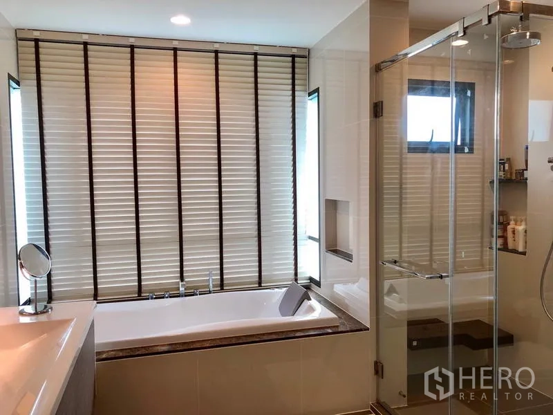 Detached House for rent or sale in Bang Kapi, Bangkok - En-suite bathroom featuring a bathtub beside the window and separate glass shower.