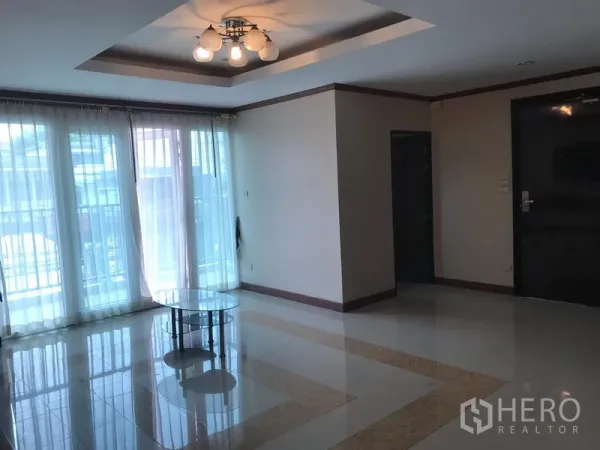 อพาร์ทเมนท์ ให้เช่าในWatthana, Bangkok - ห้องนั่งเล่นสว่างด้วยประตูกระจกเต็มสูงเปิดสู่ระเบียงและไฟเพดาน