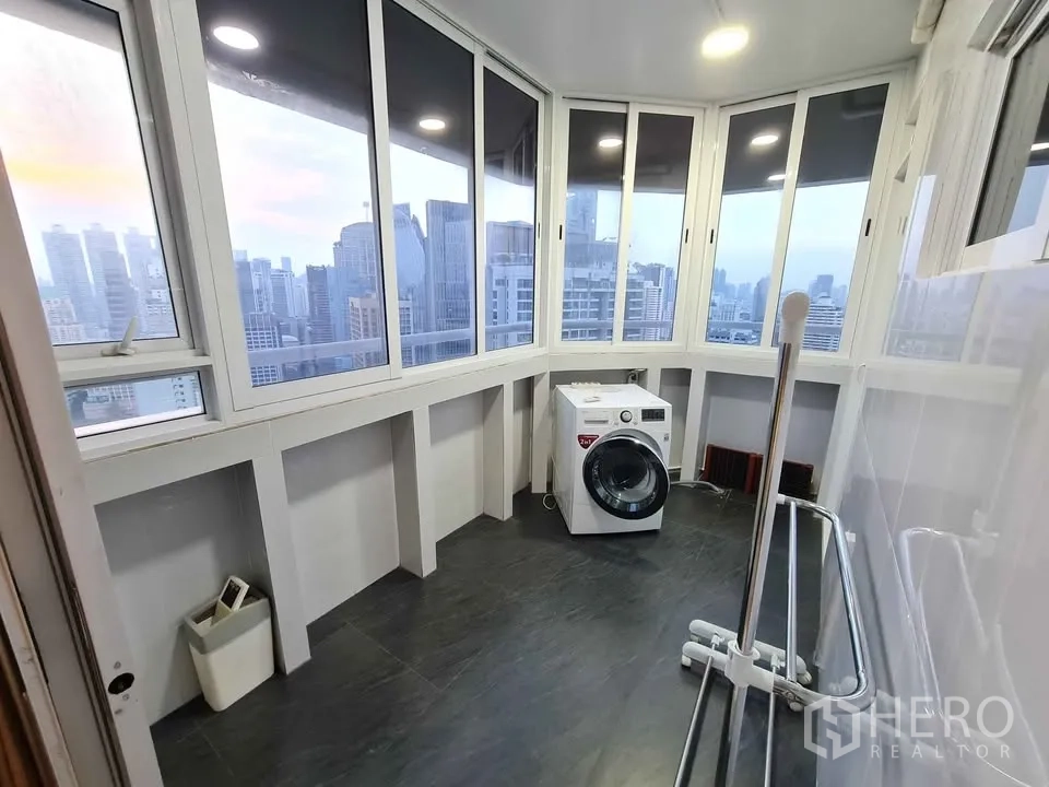 Condominium for rent in Khlong Toei, Bangkok - Primary bedroom with white bed, mirrored built-in wardrobes and side table.