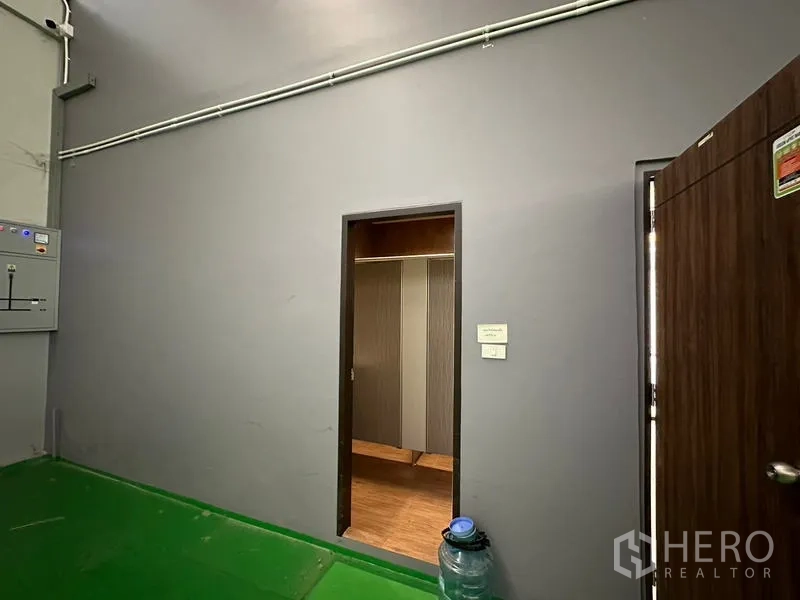 โรงงาน ให้เช่าหรือขายในLam Luk Ka, Pathum Thani - ผนังคลังสินค้ามีประตูเข้าส่วนห้องน้ำหรือห้องเปลี่ยนเสื้อผ้า ใกล้ตู้คอนโทรลไฟฟ้า.