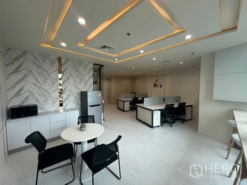 Office Space for rent - Compact pantry with fridge and microwave beside collaborative workspace.