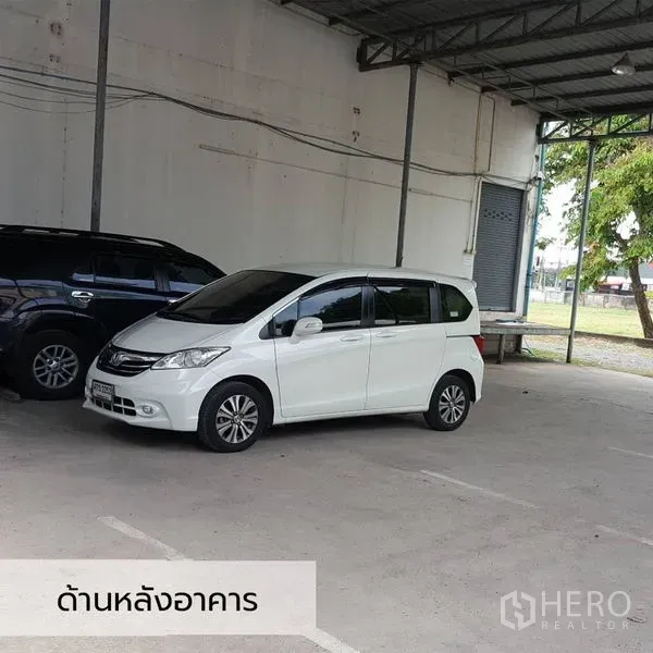 Office Space for rent in Bueng Kum, Bangkok - Covered parking area behind the building with cars under a metal roof.