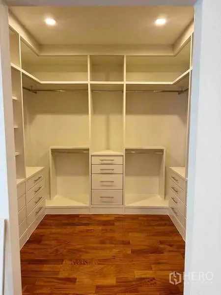 Detached House for rent in Samut Prakan - Spacious walk-in closet with built-in shelves and drawers over warm wood flooring.