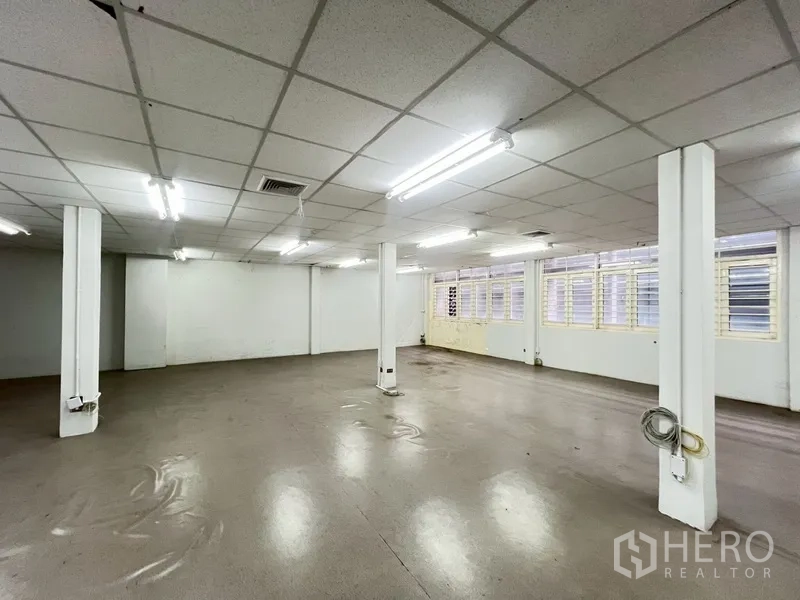 店屋 出租在Phra Khanong, Bangkok - 楼上大开间，荧光灯与百叶窗。