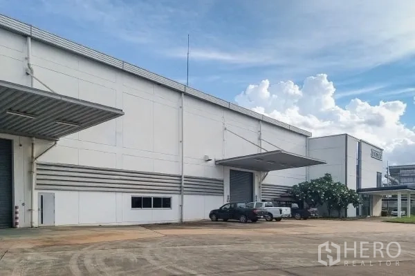 工厂 出售在Rayong - 工厂前区展示多处装卸口与停车位，景观树点缀。