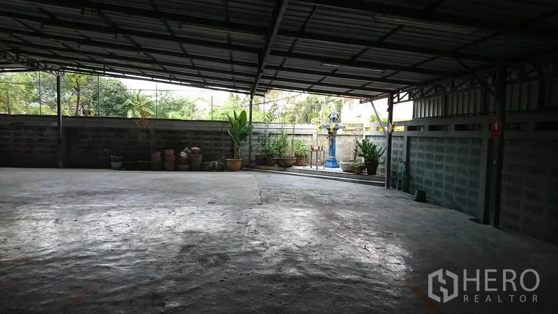 货栈 出租在Lak Si, Bangkok - 后方有顶院坪，水泥地面，矮围墙与盆栽绿植。