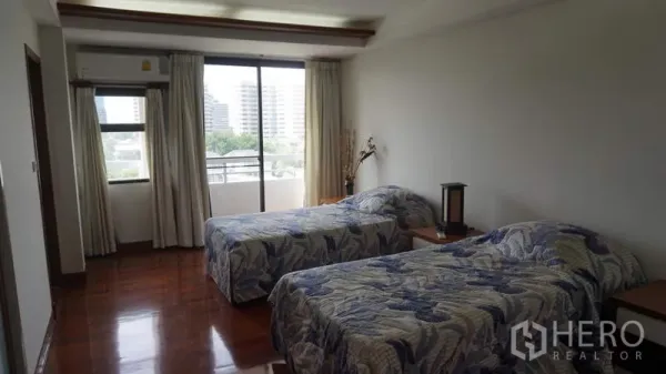 房间 出租在Khlong Toei, Bangkok - 双床卧室连接阳台，推拉落地门通向城市景观。