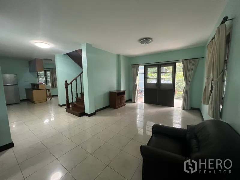 Detached House for rent in Bang Na, Bangkok - Spacious living area with tiled floor and a wooden staircase