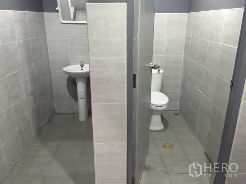Warehouse for rent in Lat Phrao, Bangkok - Restroom with pedestal sink and toilet cubicle.