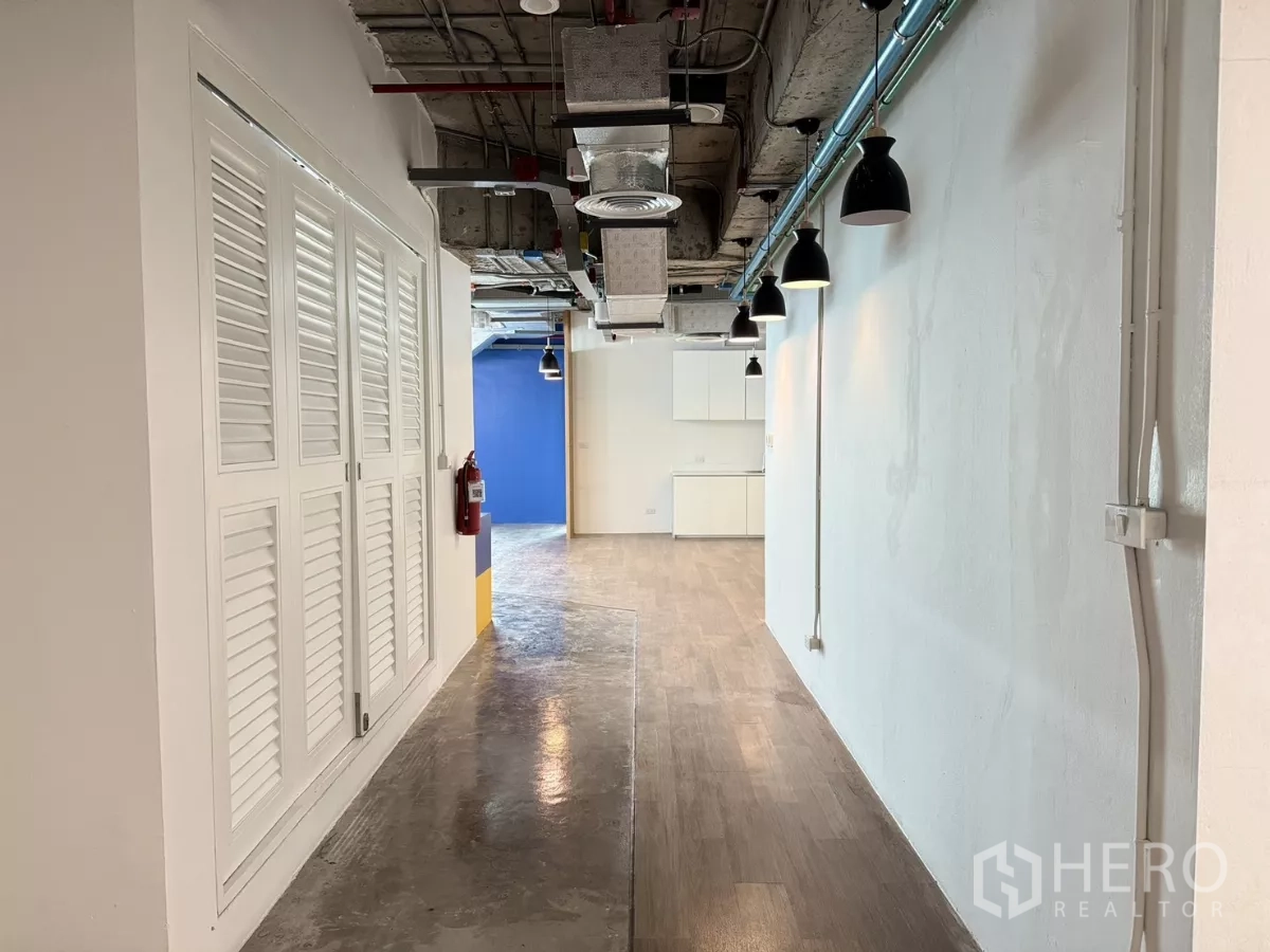 办公空间 出租在Din Daeng, Bangkok - 走廊采用工业风天花、壁灯、储物柜与混合地面材料。