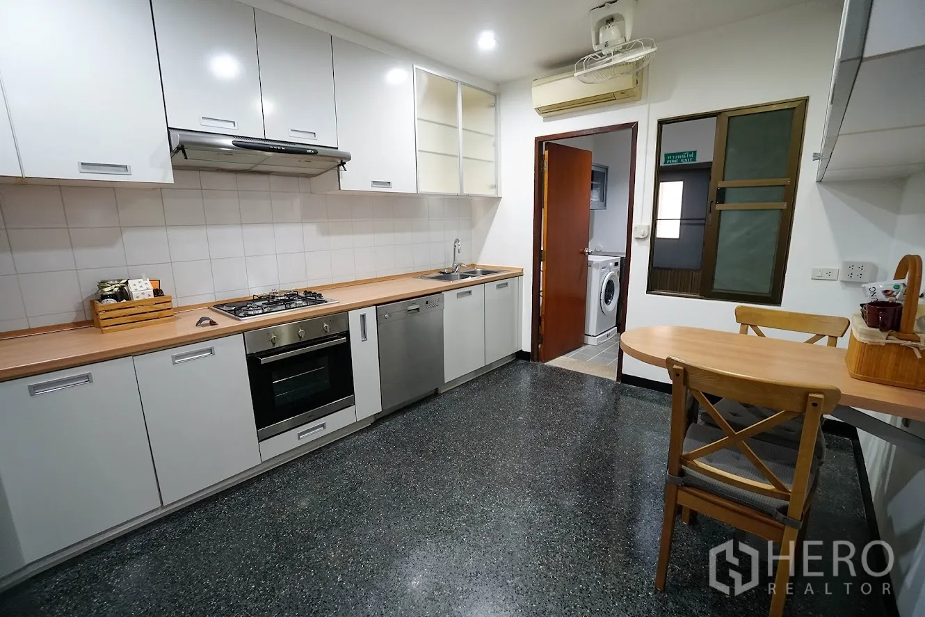 房间 出租在Watthana, Bangkok - 现代厨房，燃气灶、烤箱与后方洗衣间。