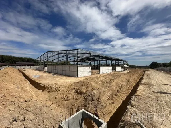 คลังสินค้า ให้เช่าหรือขายในNikhom Phatthana, Rayong - มุมกว้างโครงสร้างเหล็กโกดังสร้างใหม่กำลังก่อสร้าง พร้อมงานขุดร่องดิน ภายใต้ท้องฟ้าโปร่งในระยอง