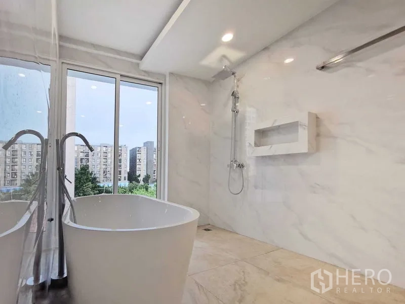 Home Office for sale in Suan Luang, Bangkok - Marble bathroom with a freestanding bathtub and walk-in shower with city view.