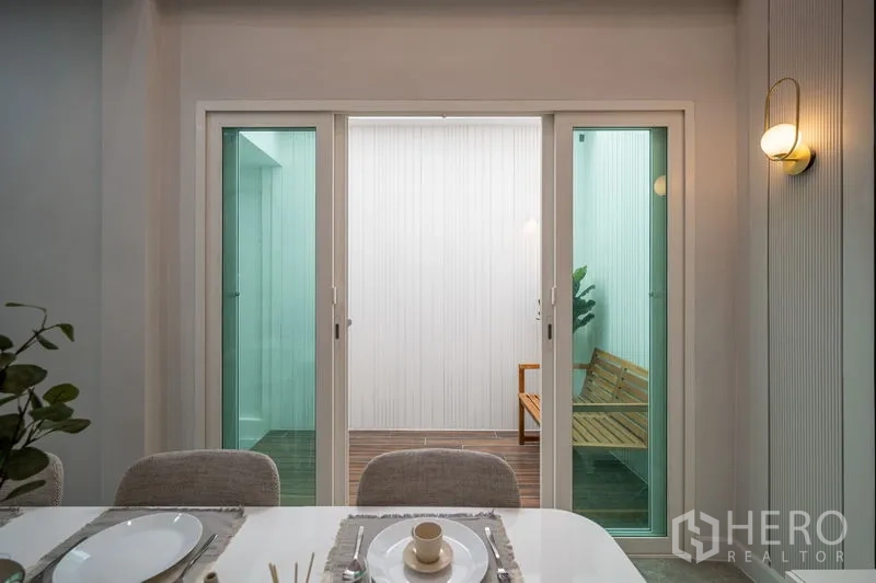 Townhouse for sale in Din Daeng, Bangkok - Dining area opening to the glass-enclosed courtyard for abundant natural light.