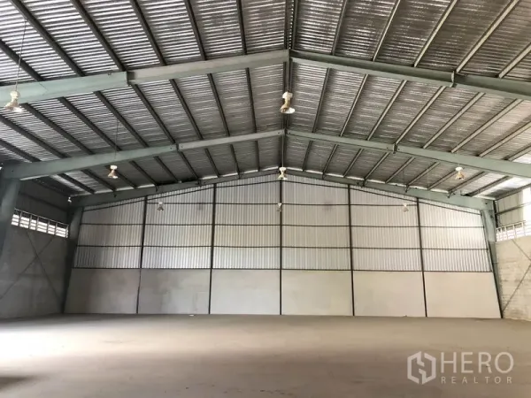 Warehouse for rent in Sai Noi, Nonthaburi - Spacious warehouse interior with clear-span steel trusses, high gabled roof and smooth concrete floor.