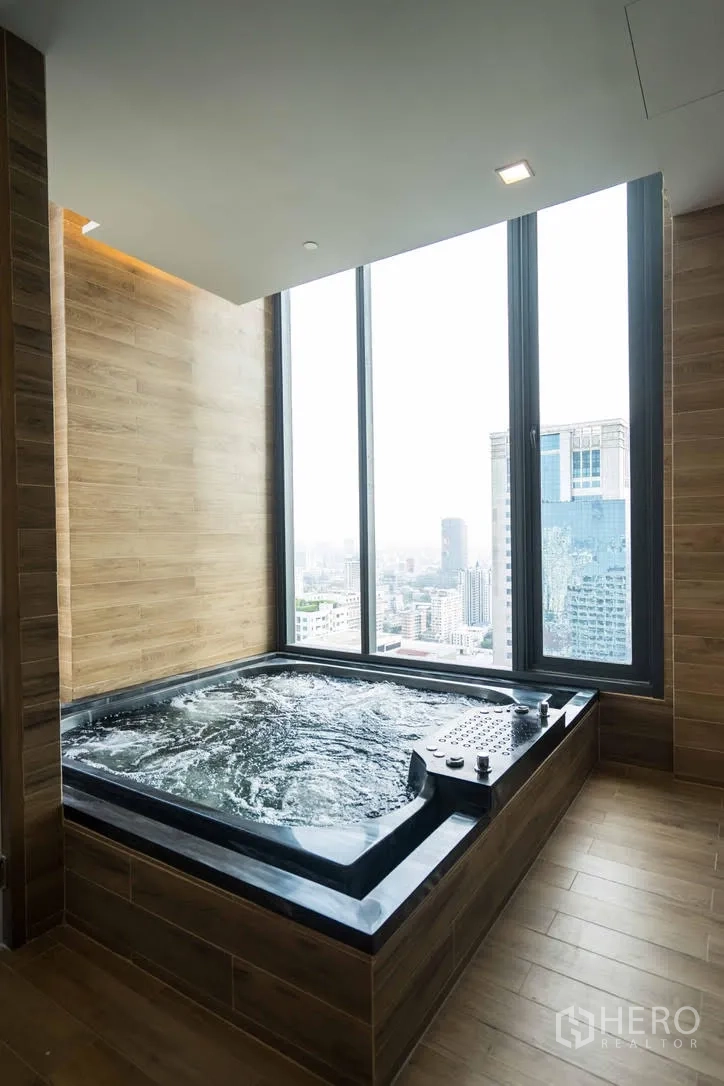 Condominium for rent in Watthana, Bangkok - Indoor jacuzzi spa beside full-height windows overlooking the city.