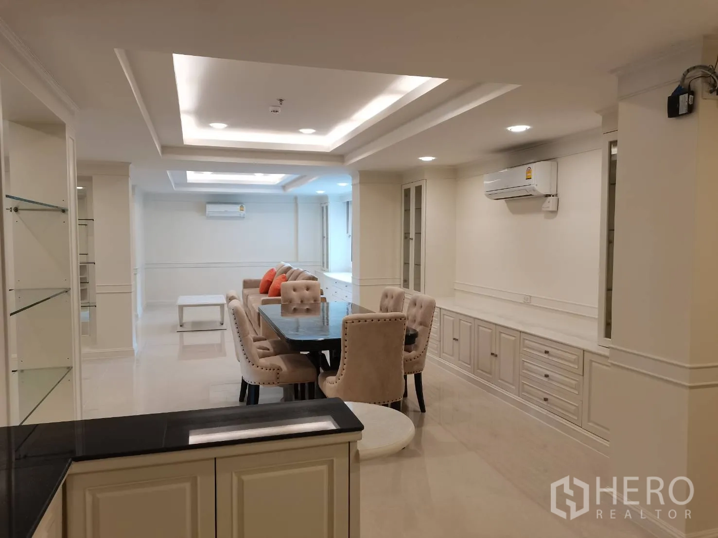 Condominium for rent in Watthana, Bangkok - Open-plan living and dining space with built-in cabinets and ceiling spotlights.