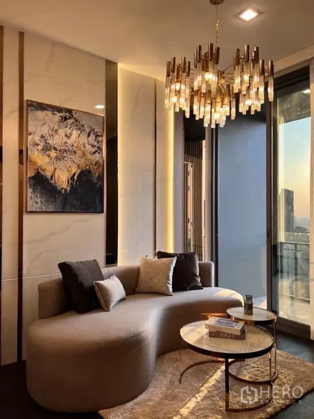 Condominium for rent in Watthana, Bangkok - Living area with floor-to-ceiling windows, balcony access, and sunset city views.