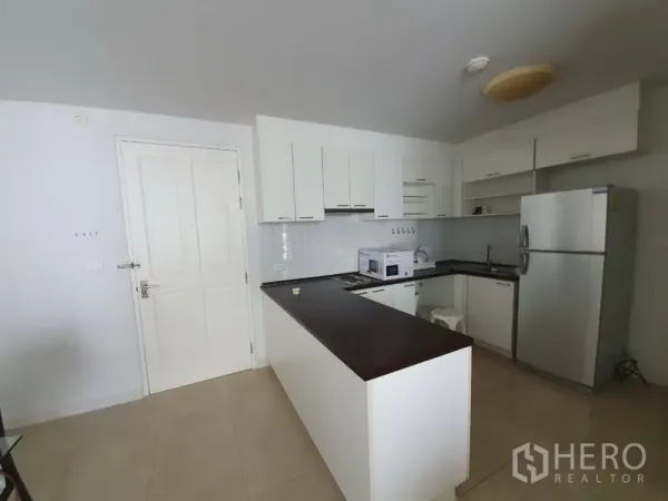 公寓 出租在Yan Nawa, Bangkok - 白色L型开放式厨房，带吧台、微波炉和冰箱