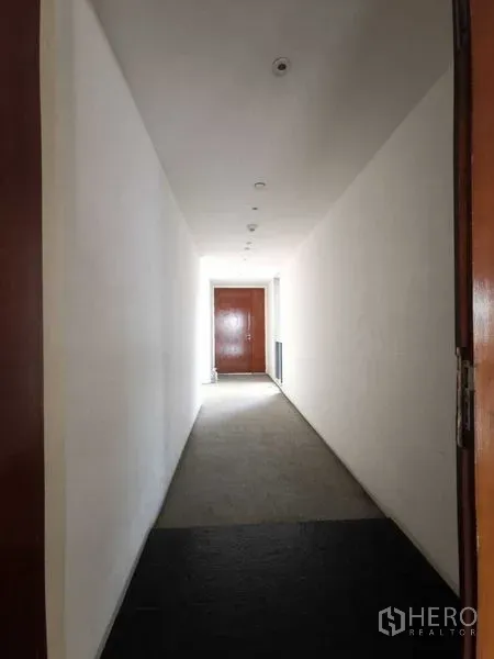 公寓 出租在Yan Nawa, Bangkok - 带筒灯的长走廊，尽头为实木入户门。