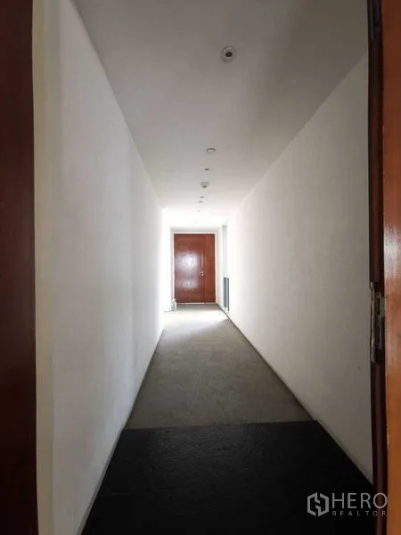 公寓 出租在Yan Nawa, Bangkok - 带筒灯的长走廊，尽头为实木入户门。