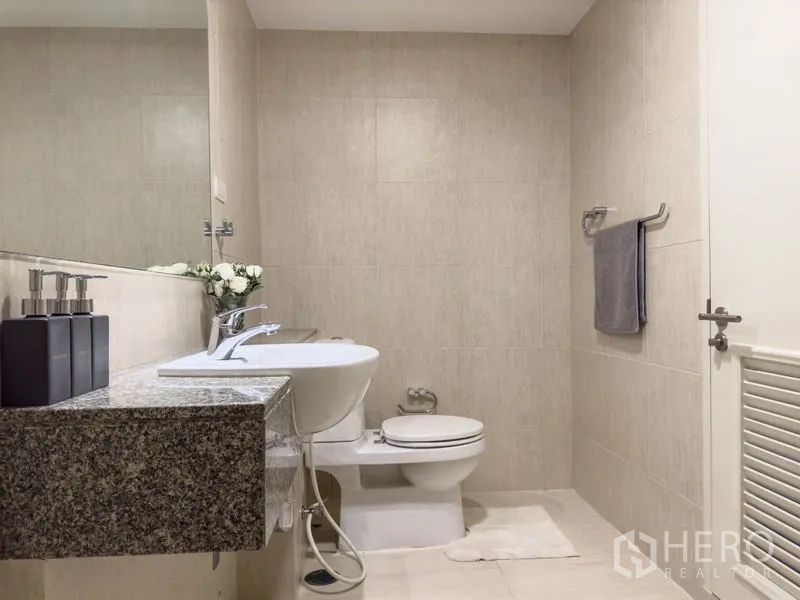 Condominium for sale in Watthana, Bangkok - Spacious bathroom with granite vanity, toilet, and towel rail.
