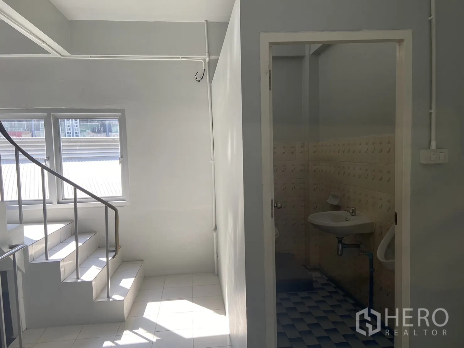 店屋 出租在Bang Na, Bangkok - 带窗采光的楼梯间，旁边为瓷砖卫生间入口