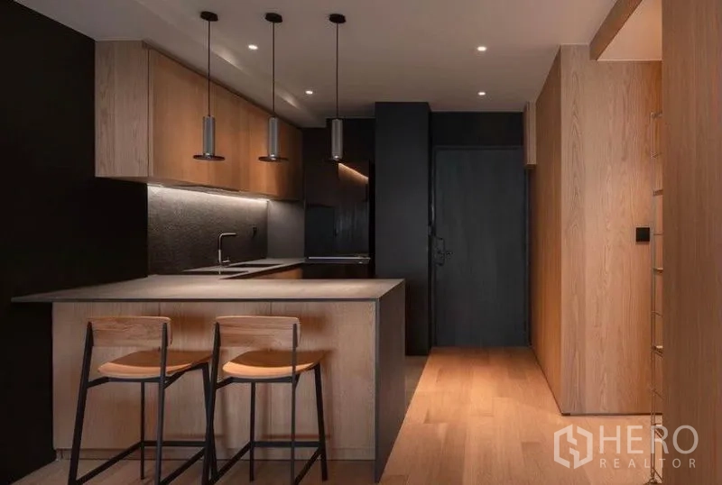 คอนโด ให้เช่าในPhaya Thai, Bangkok - ครัวดีไซน์โมเดิร์น มีไอส์แลนด์บาร์ เก้าอี้สองตัว ตู้ไม้ และผนังโทนเข้ม