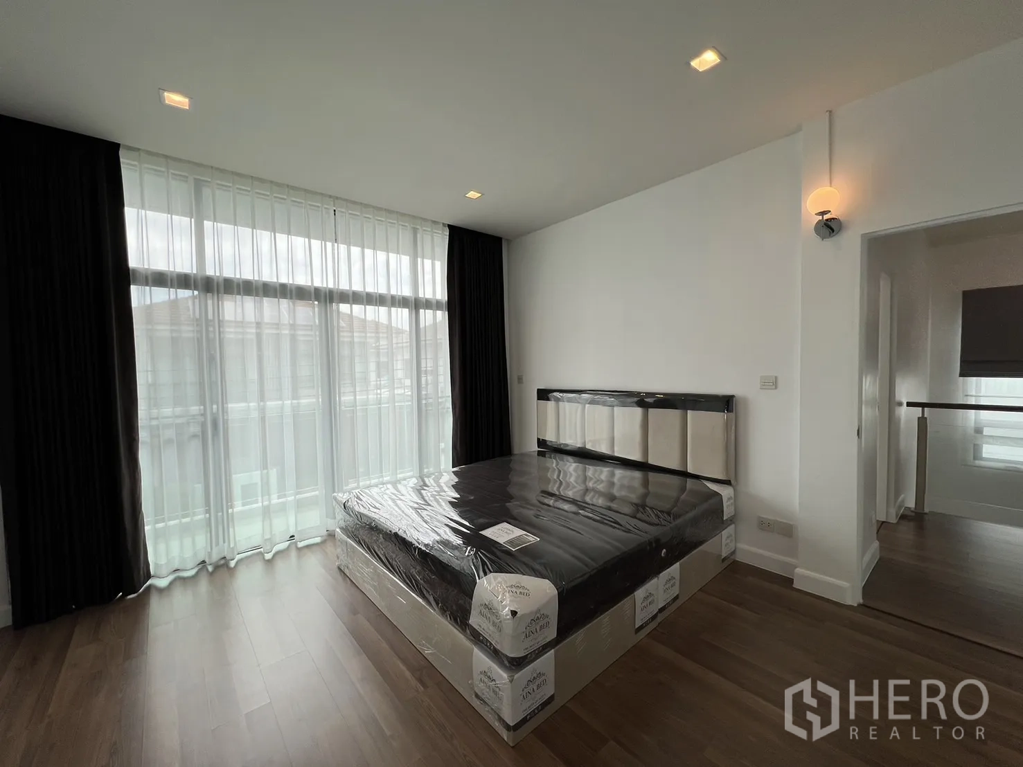 独立式住宅 出租在Bang Kapi, Bangkok - 主卧，落地大窗、木地板与新床架。