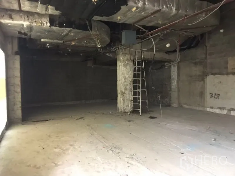 零售空间 出租在Bang Rak, Bangkok - 一层临街零售毛坯铺，裸露天花、混凝土立柱与未完工地面。