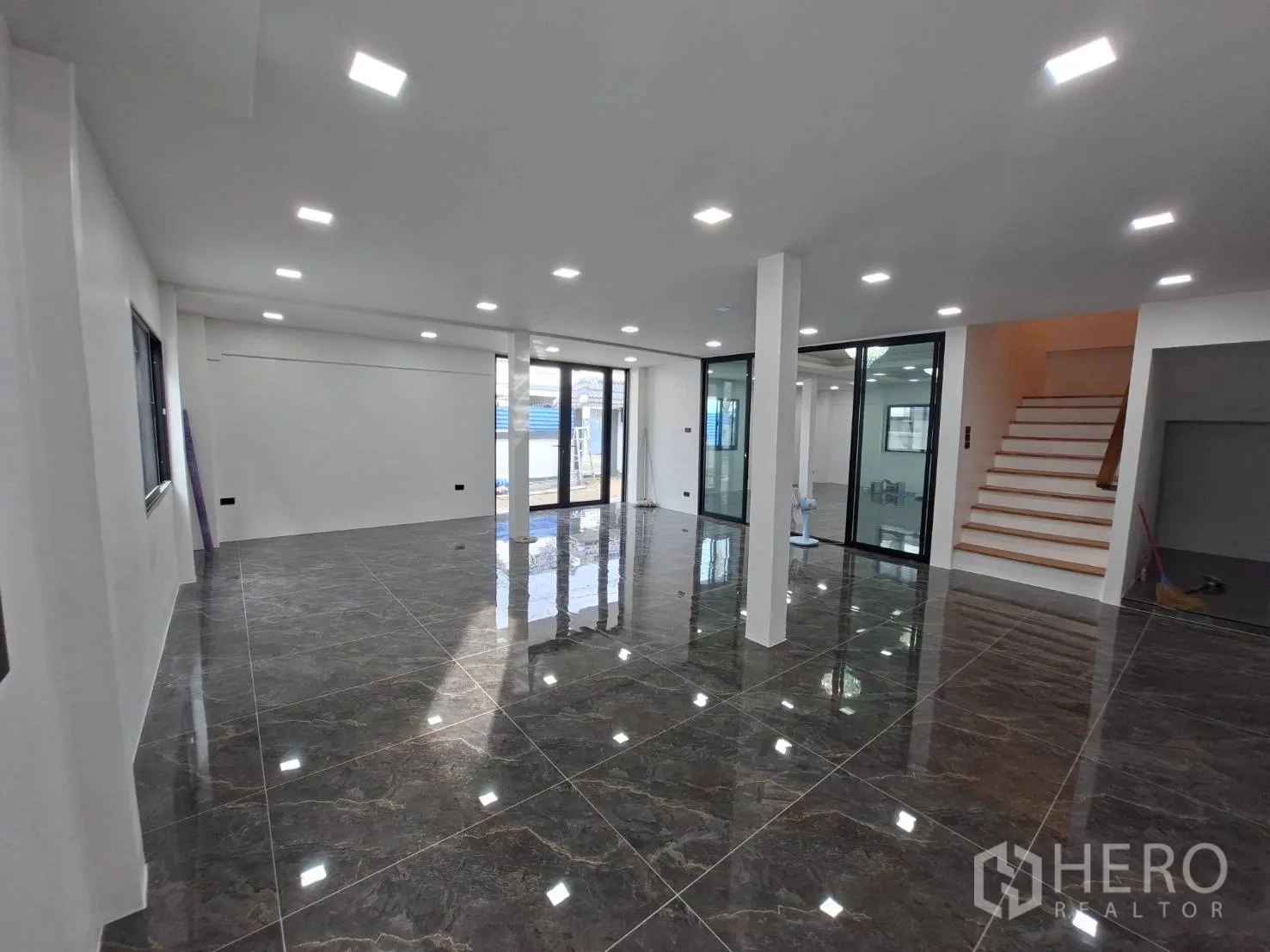 家庭办公室 for rent in Phra Khanong, Bangkok - 宽敞办公区，带玻璃隔断与通向楼上的楼梯。