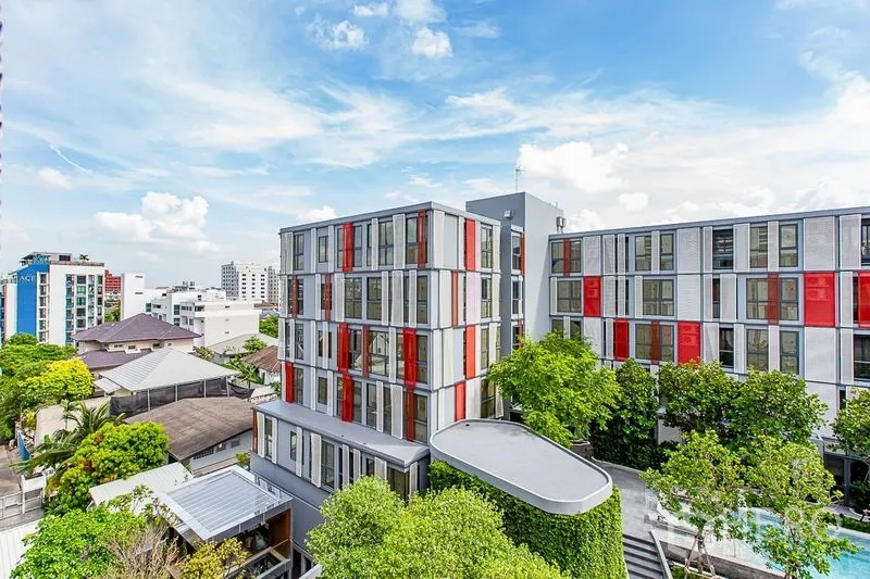 คอนโด ให้เช่าในWatthana, Bangkok - อาคารคอนโดโลว์ไรส์สไตล์โมเดิร์น ฟาซาดสีแดงสลับขาว รายล้อมด้วยต้นไม้และวิวเมือง