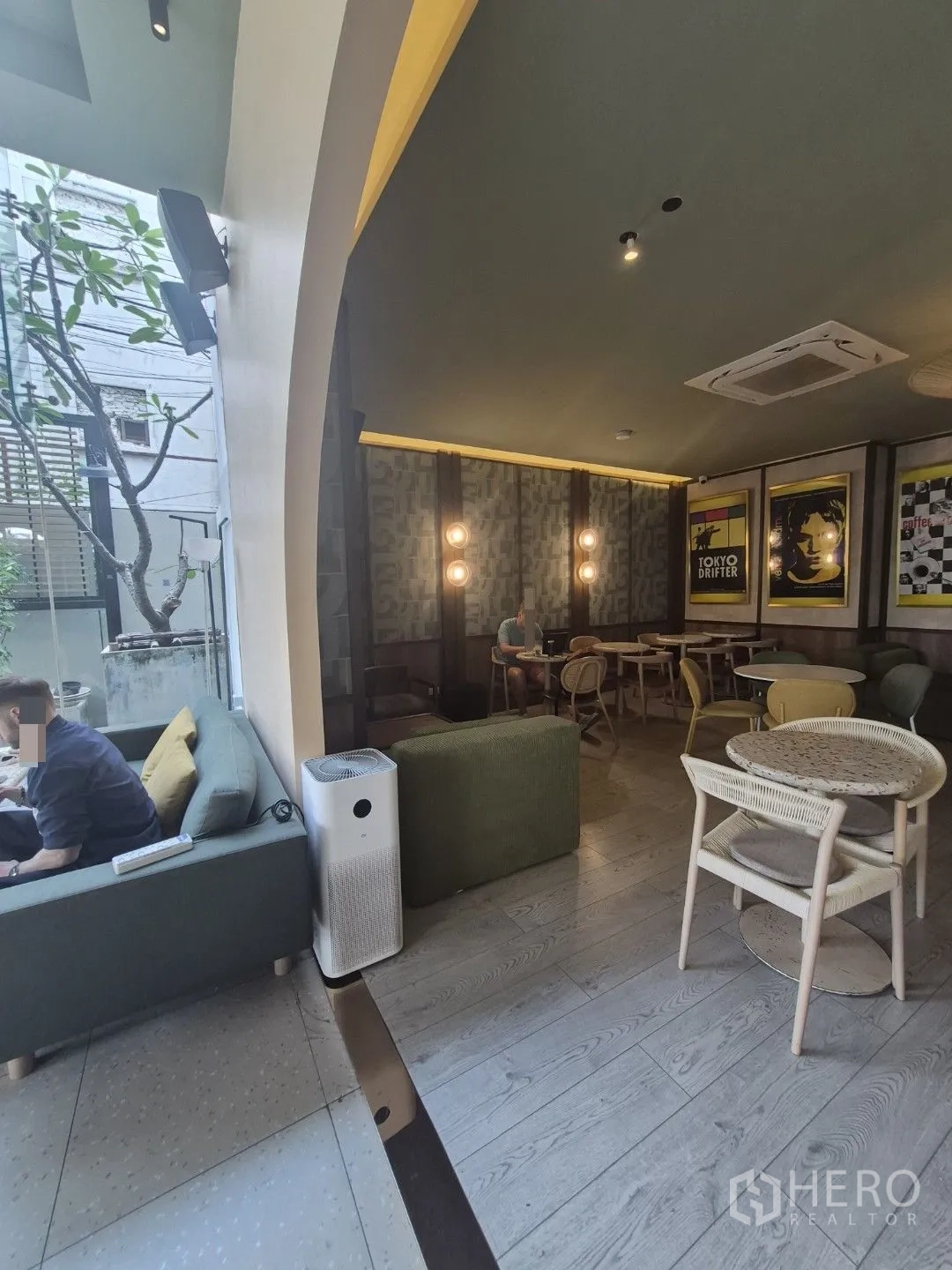 零售空间 for rent in Watthana, Bangkok - 咖啡馆风室内，设有沙发、圆桌、木地板与大型拱形窗。