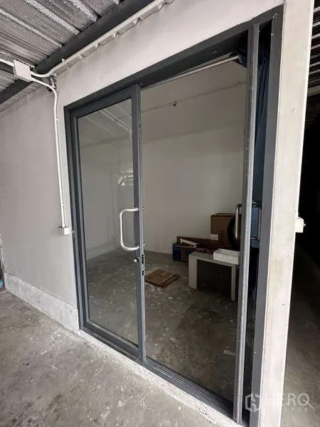 Factory for rent in Lam Luk Ka, Pathum Thani - Small utility room with glass sliding door and concrete floor.
