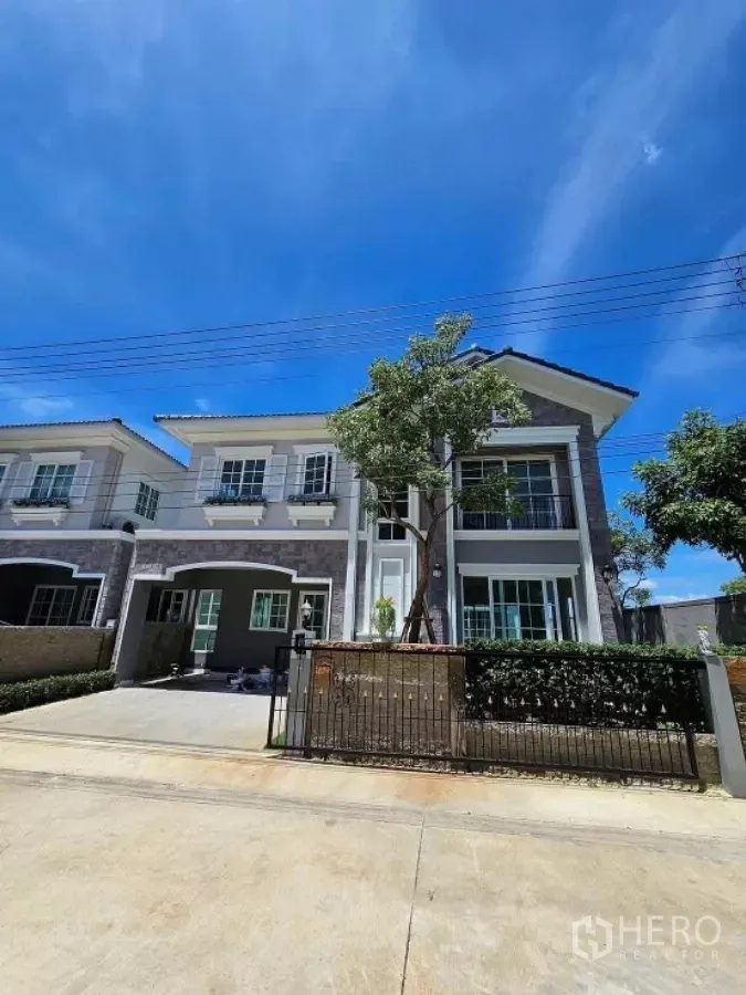 Detached House for rent in Thanyaburi, Pathum Thani - Modern two-storey detached house with driveway and front gate under a blue sky in Thanyaburi.