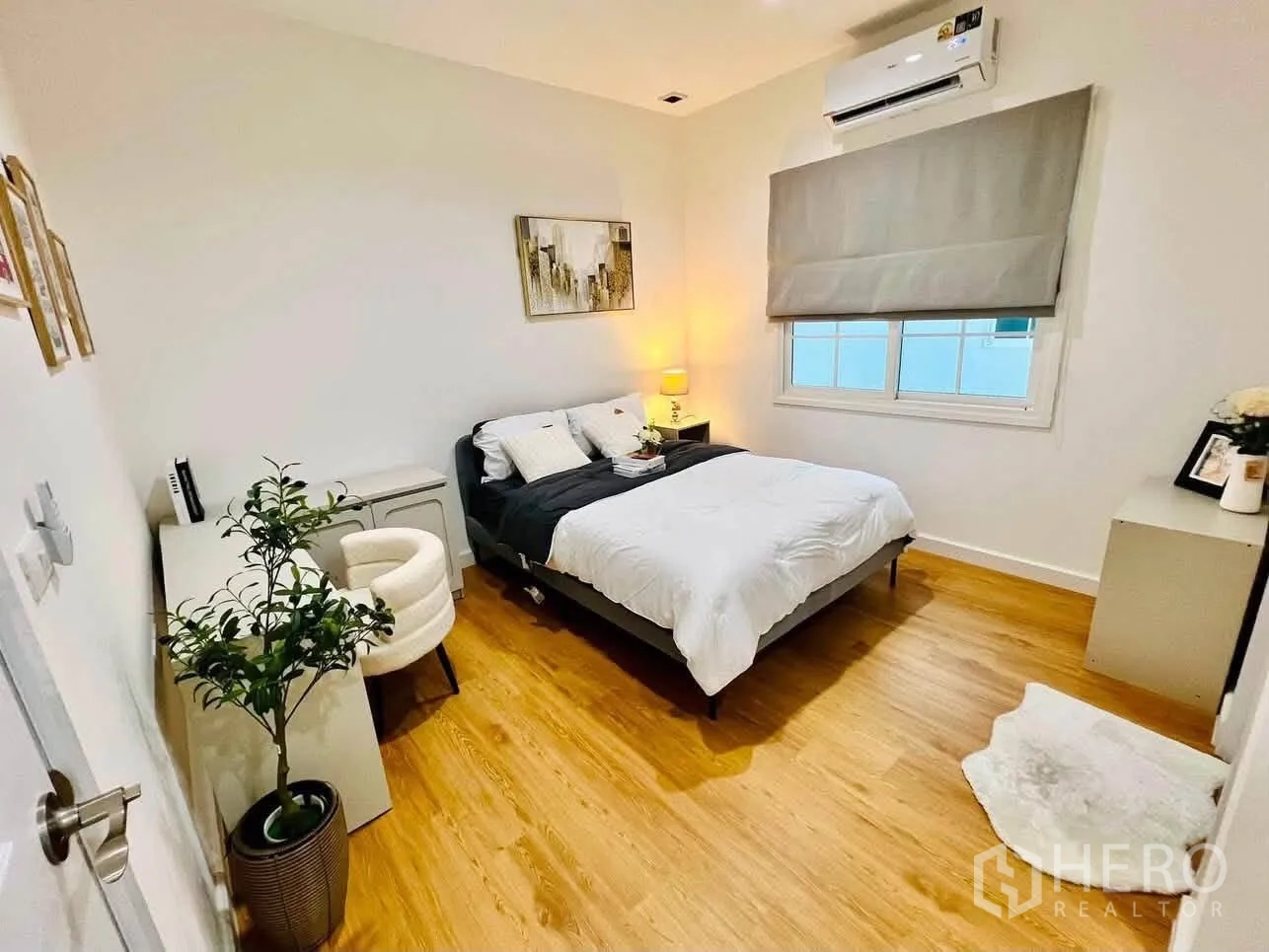 Detached House for rent in Bang Phli, Samut Prakan - Cozy bedroom with wood floors, double bed, desk, and a window with blinds.