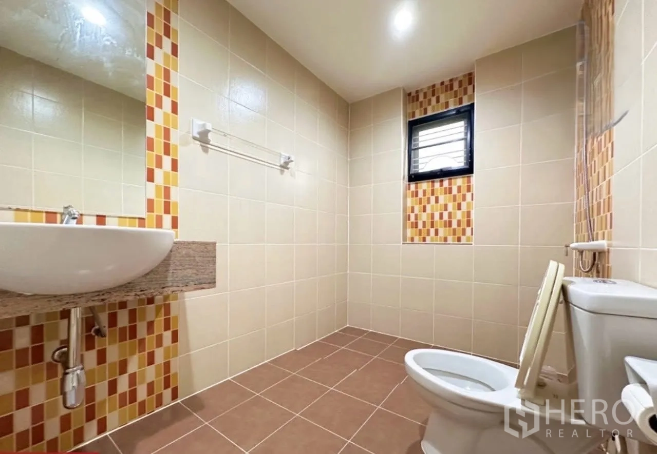 บ้าน ขายในLam Luk Ka, Pathum Thani - ห้องน้ำโทนเบจ กรุกระเบื้องลายโมเสก อ่างล้างหน้าแขวนผนัง และโถสุขภัณฑ์