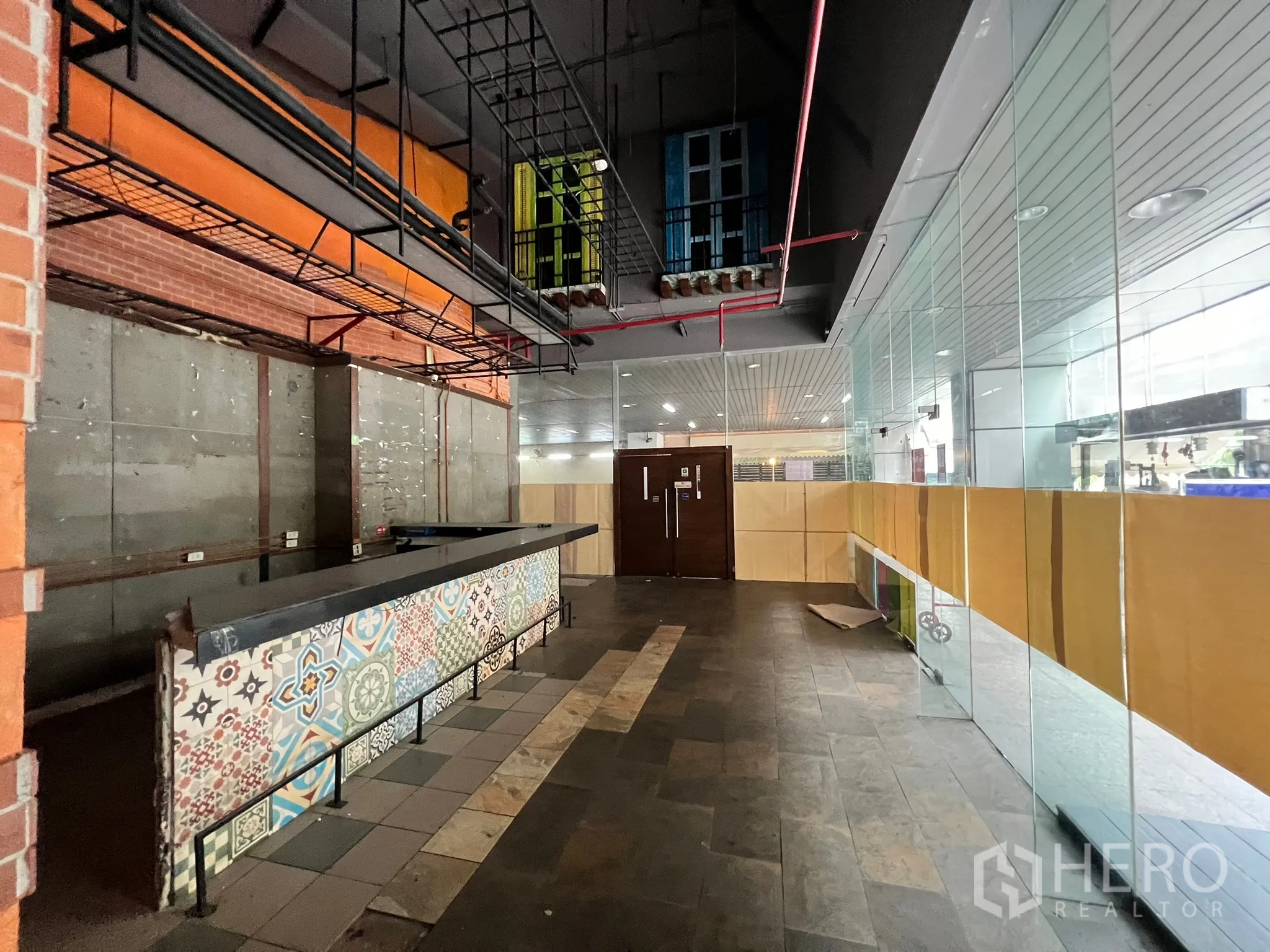 零售空间 出租在Watthana, Bangkok - 长形花纹服务吧台对着整面玻璃店面与走廊。