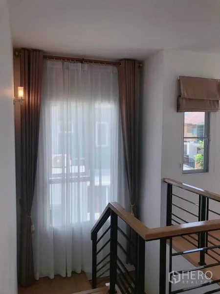 บ้าน ขายในSuan Luang, Bangkok - บันไดรับแสงธรรมชาติ มีหน้าต่างและราวไม้พร้อมม่านโปร่ง