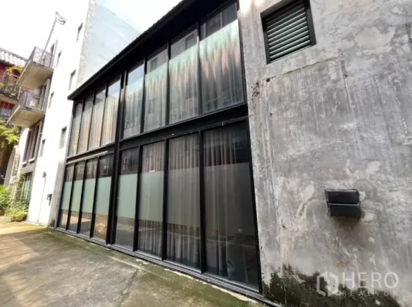 带办公室的家 出租在Pathum Wan, Bangkok - 四层家用办公楼外立面，黑色框架落地玻璃。