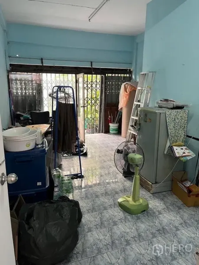 店屋 出租在Khlong Toei, Bangkok - 一层前厅，浅蓝墙面与推拉金属门。